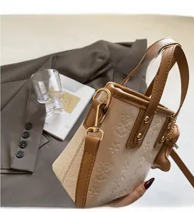 Nahaufnahme der cremefarbenen Ledertasche mit Sternprägung und Goldmetallhaken