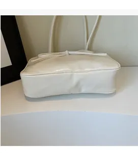 Detail of the bow decoration and smooth cream-colored PU leather texture on a Boston bag