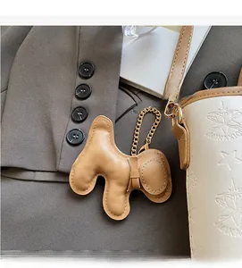 Detailansicht eines braunen Leder-Welpen-Anhängers an einer weißen Tasche mit Sternprägung
