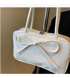 Close-up of a white ballet-style Boston bag with a large bow and silver dual zippers