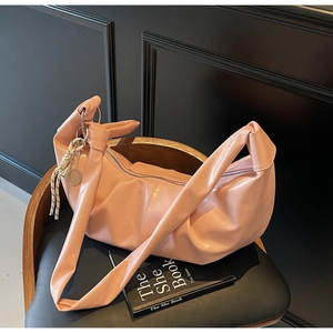 Detailed close-up of pink hobo bag with knotted handle and soft pleated texture