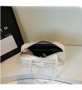 Top view of open white bow shoulder bag showing spacious interior for tablet and phone