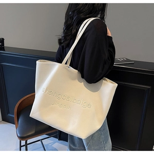 Detail of the large-capacity cream canvas tote bag with embossed letter decoration
