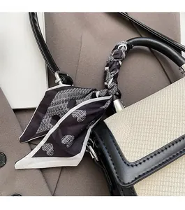 Détail du sac à main bicolore avec poignée foulard en soie et panneaux tissés