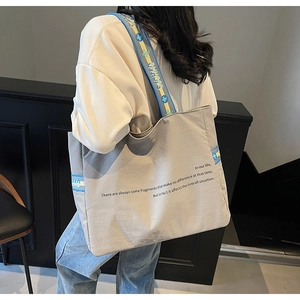 Détail d'un grand cabas gris avec bandoulière jacquard et texte imprimé tendance