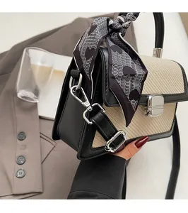 Détail du sac bicolore élégant avec fermoir argenté et poignée en soie à cœurs