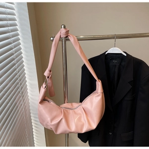 Detail of soft pink crescent bag featuring pleated PU leather and knotted shoulder strap