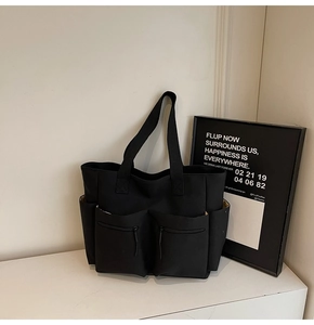 Macro shot of durable black nylon tote bag featuring four functional external zipper pockets