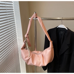 Detail of pink pleated hobo bag with wide knotted strap and textured PU material