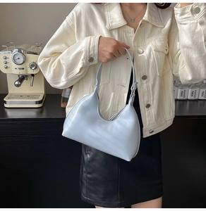 Detail of light blue crescent underarm bag with smooth PU finish and silver zipper