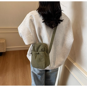 Army green nylon crossbody bag detail showing drawstring pocket and lightweight texture