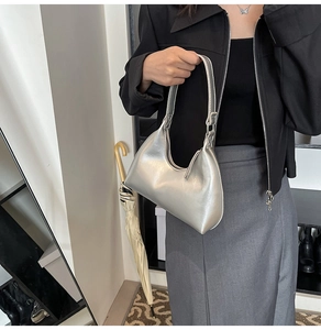 Detail view of a silver metallic hobo bag with sleek minimalist design and smooth zipper