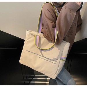 Détail du sac cabas en toile beige avec bandoulière tissée colorée en vue lifestyle