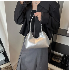 Detailed view of silver metallic crescent hobo bag with reflective PU leather texture