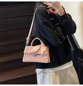 Photo lifestyle d'un sac carré en cuir tressé rose avec foulard cœur d'escalier