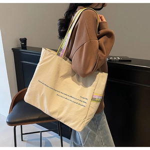 Détail du sac cabas en toile avec bandoulière large colorée et logo S.J.CHAO