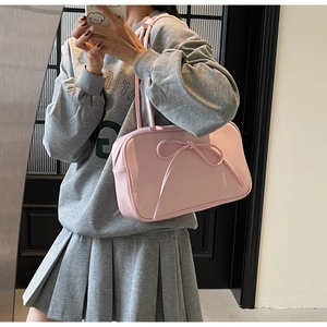Detailed mirror selfie showing a pink bow-knot hobo bag with sleek PU leather texture