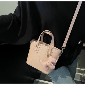 Detail der rosa Kunstleder-Beuteltasche mit Sternprägung und Plüschanhänger
