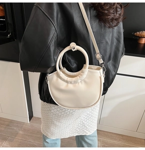 Detailed view of cream PU leather crossbody bag with circular handle and pleated texture