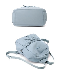 Detail view of smog blue nylon backpack showing drawstring bow and side profile