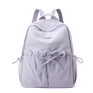 Detail of lavender nylon backpack featuring drawstring pleats and bow decoration