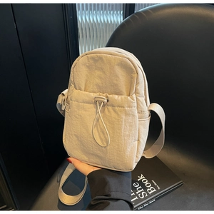 Detail of light beige nylon mini crossbody bag with drawstring pocket and wide strap