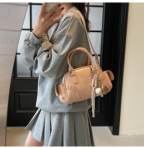 Detail of peach pink Boston bag with embossed lettering and baseball-style stitching