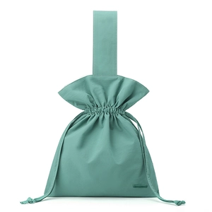 Detail of the drawstring closure and ruffled edge on a light green nylon handbag