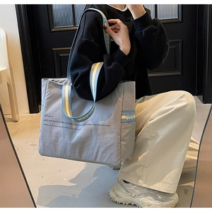 Détail du grand sac cabas gris avec bandoulière tissée et poche latérale pratique