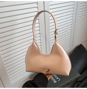 Close-up of minimalist glossy nude pink crescent underarm bag with top silver zipper