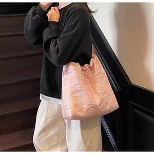 Detail of pink canvas tote bag with colorful wavy embroidery and drawstring closure