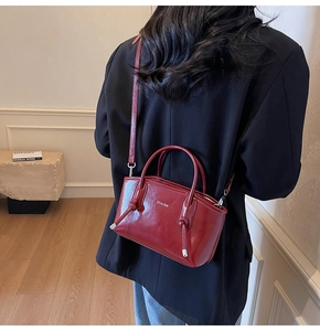Dettaglio della borsa bordeaux in vernice con texture lucida e fibbia in metallo argento