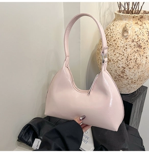 Detail of light pink hobo bag with glossy finish and secure zipper closure