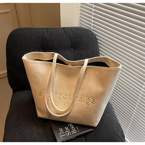 Detail of canvas tote bag with embossed lettering on a minimalist studio background