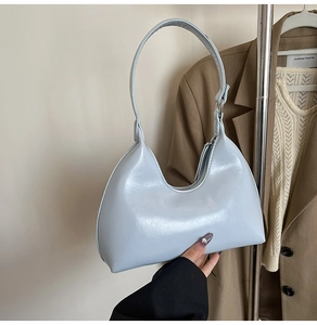 Close-up of light blue patent leather hobo bag with sleek zipper and glossy texture