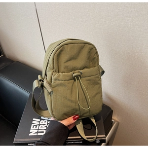 Detail of army green nylon crossbody bag with drawstring pocket and adjustable strap