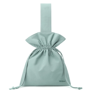 Detail of mint green nylon drawstring pouch with ruffled edge and woven brand label