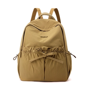 Detail of khaki nylon backpack featuring comfort pop logo and bow tie zipper pocket
