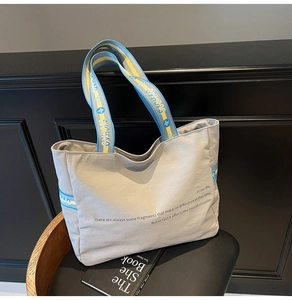 Détail d'un sac fourre-tout en toile avec sangles contrastées bleu et jaune sur chaise