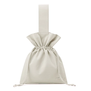 Macro detail of the cream nylon fabric texture and drawstring closure on the handbag