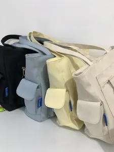 Detailed close-up of cream-colored tote bags in four pastel colors with side flap pockets