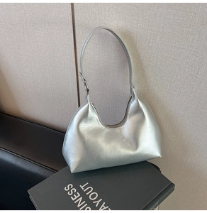 Detailed view of a silver metallic hobo bag with a sleek crescent design and smooth texture