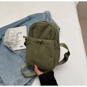 Olive green nylon crossbody bag featuring adjustable strap and drawstring pocket detail
