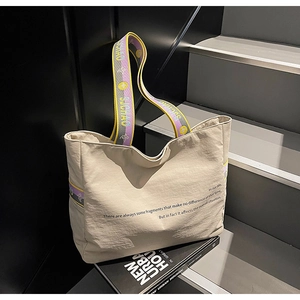 Détail du sac cabas en toile beige avec bandoulière violette et design texturé unique