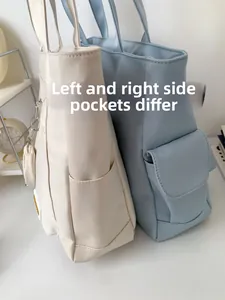 Detail of asymmetric side pockets on milk white and light blue canvas tote bags