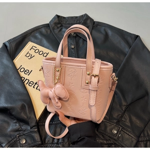 Detail der hellrosa Beuteltasche mit Sternprägung und Plüsch-Hundeanhänger