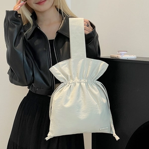 Close-up of minimalist nylon drawstring bucket bag with ruffles and wide shoulder strap