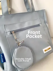 Detail of light blue tote bag with front zipper pocket and round coin purse attachment