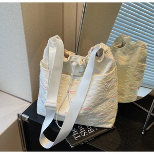 Detail of white wrinkled canvas tote featuring colorful wavy embroidery and drawstring