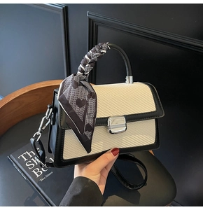 Détail du sac tressé contrasté avec poignée en foulard et fermoir en métal argenté